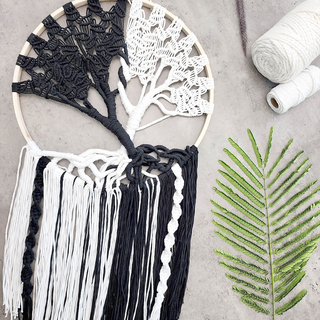 “Yin Yang Tree” by ArtixHub – black & white macramé tree wall hanging with contrasting strands and fringe, embodying balance and harmony. Ideal for meditation rooms, home offices, or contemporary living areas, enhancing UAE spaces with modern bohemian flair.
